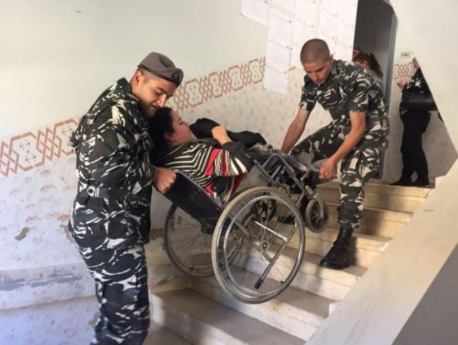 عناصر قوى الأمن تساعد امراة من ذوي الإحتياجات الخاصة للإدلاء بصوتها في أحد مراكز الإقتراع في البقاع