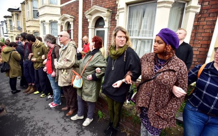 Neighbours form human chain to prevent family being evicted 