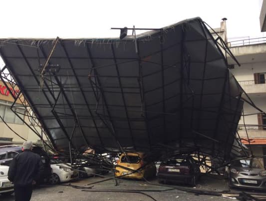 بالصور: سقوط لوحة اعلانية على عدد من السيارات في الزلقا