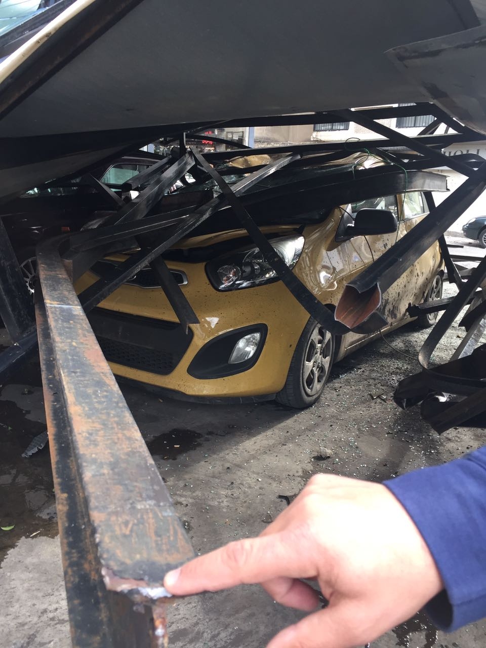 بالصور: سقوط لوحة اعلانية على عدد من السيارات في الزلقا