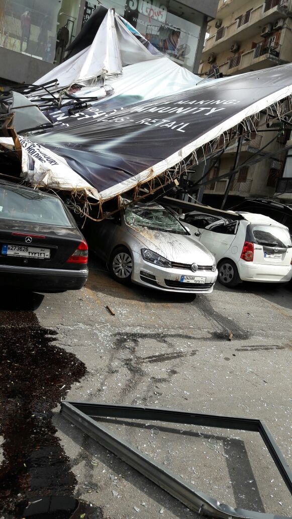 بالصور: سقوط لوحة اعلانية على عدد من السيارات في الزلقا