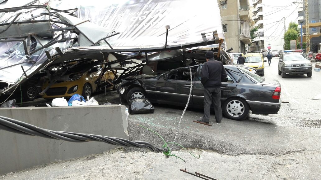 بالصور: سقوط لوحة اعلانية على عدد من السيارات في الزلقا