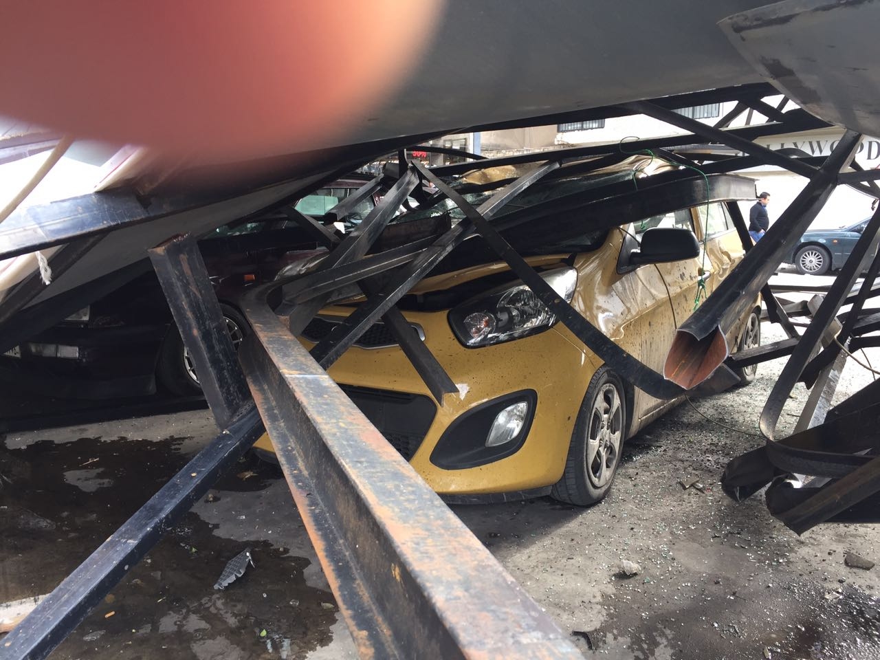 بالصور: سقوط لوحة اعلانية على عدد من السيارات في الزلقا