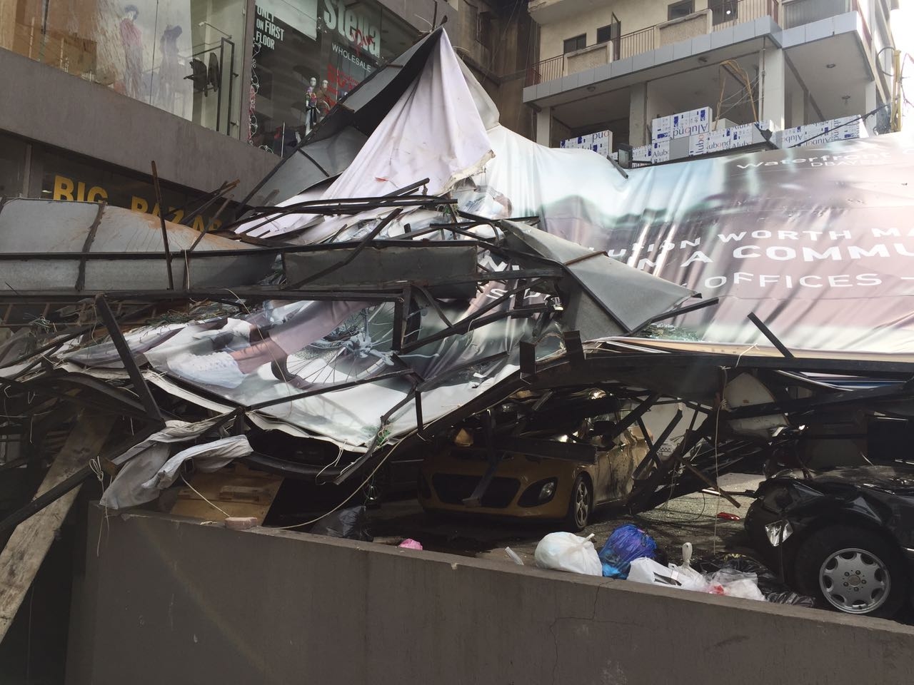 بالصور: سقوط لوحة اعلانية على عدد من السيارات في الزلقا