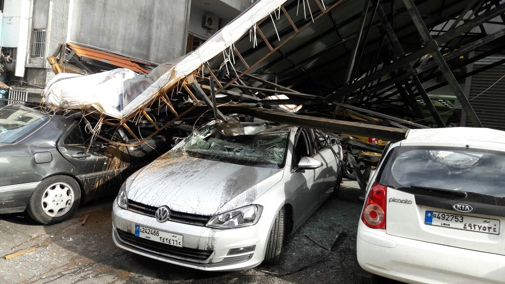 بالصور: سقوط لوحة اعلانية على عدد من السيارات في الزلقا