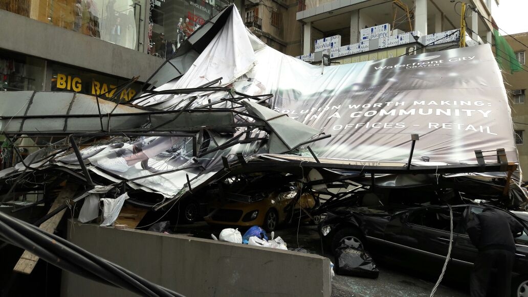 بالصور: سقوط لوحة اعلانية على عدد من السيارات في الزلقا