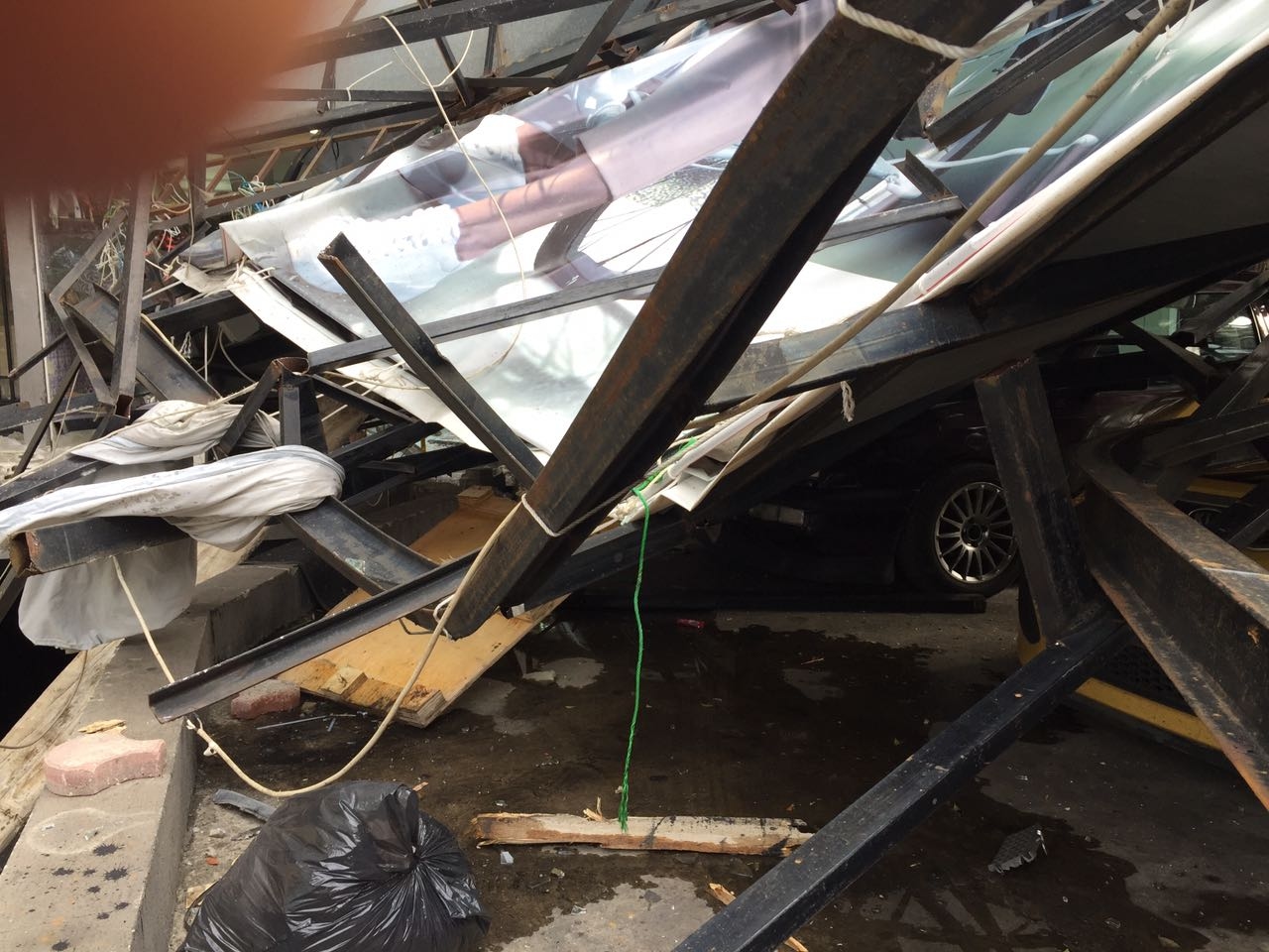 بالصور: سقوط لوحة اعلانية على عدد من السيارات في الزلقا