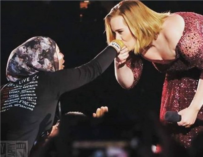 بالصورة: أديل تقبّل يد فتاة مسلمة وهذا ما قالته لها
