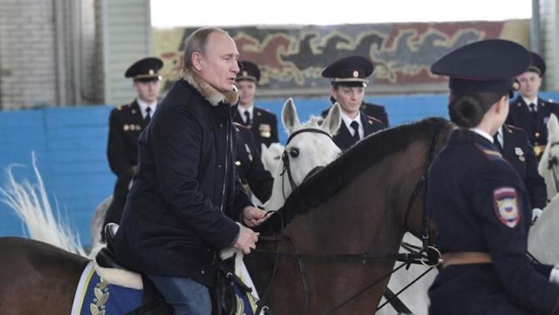 Russia's Putin rides horse with female police ahead of International Women's Day