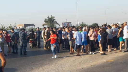 Young men gather at the entrance of alNaameh landfill to protest its reopening