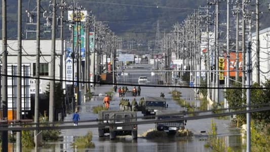 Japan rescuers wade in muddy waters to find typhoon survivors