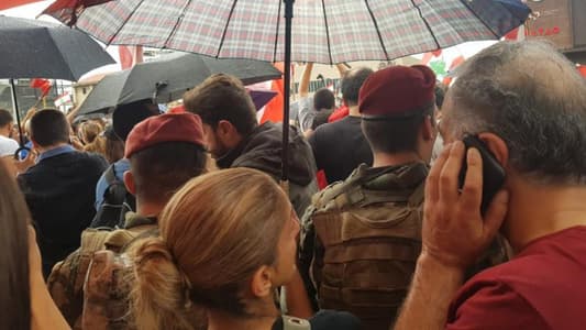 Photo: Protesters protecting army soldiers from the rain with umbrellas in Jal El-Dib