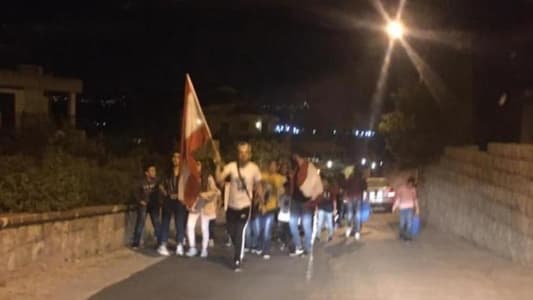 Protesters march in Ibil Saqi holding candles and pots