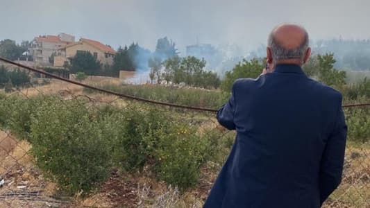 Former MP Fares Souaid is inspecting the site of an Israeli shell's impact in the outskirts of Qartaba