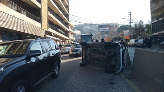 Photo: A car overturned on the Jamhour highway near Bsous junction, causing material damage, while traffic is active and a patrol officer from the Baabda Traffic Division is on-site to handle the situation