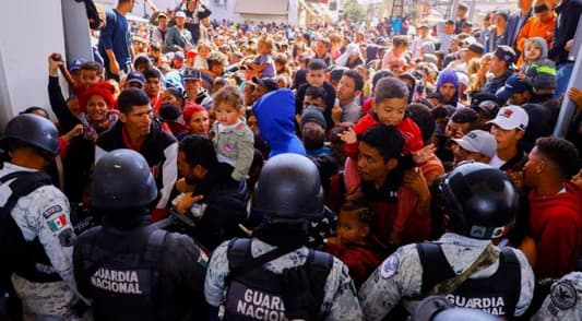 Hundreds of migrants try to force their way into US at Mexico border