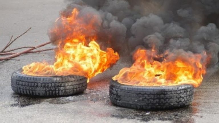 Protesters block Deir Mimas road with burning tires