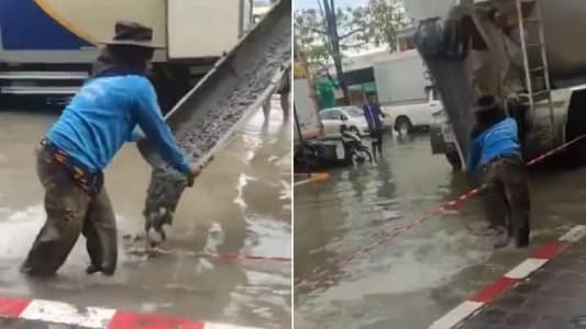Bangkok Road Workers Continue Pouring Cement Into Roadway During Flood