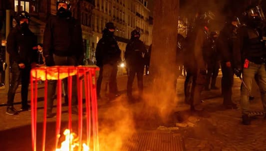 Protesters set rubbish on fire as French government barely survives no-confidence vote